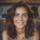 Femme souriante aux cheveux bruns et yeux verts.
