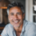 Homme souriant avec des cheveux gris.